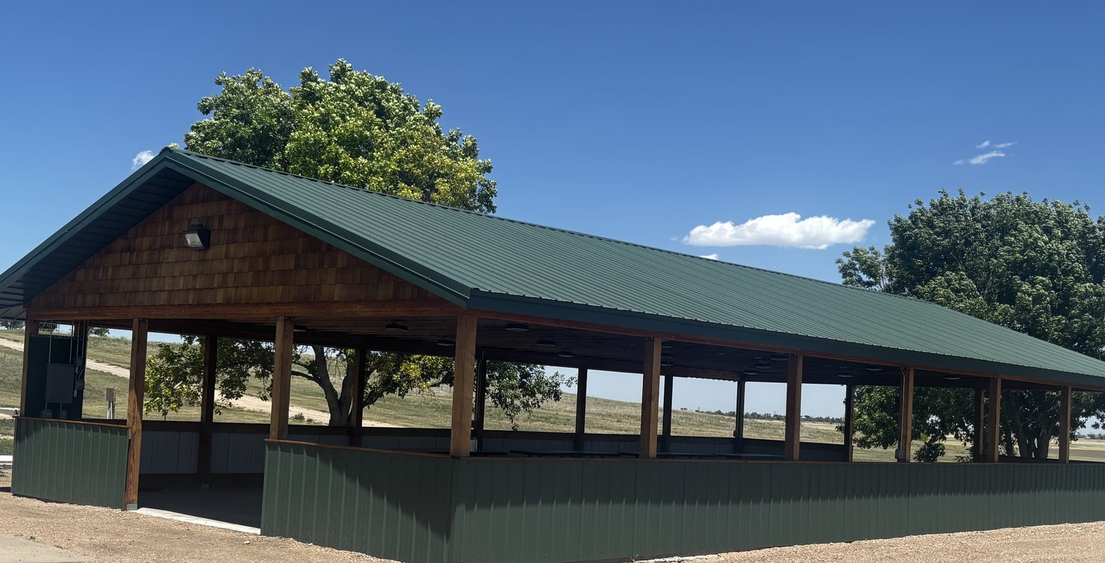 The new F&H community pavilion — green metal roof and timber posts, standing beside the clubhouse